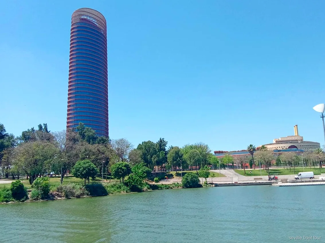 Torre Sevilla et la rive verdoyante de la Cartuja vues d'une balade en bateau à Séville